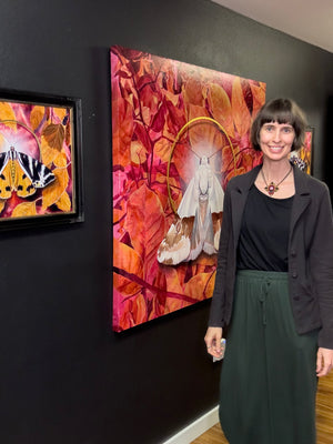 artist Aimee Schreiber standing in front of large pink and white moth painting