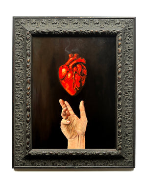 Artistic depiction of a hand holding a glowing red heart against a dark background, framed in ornate black wood.