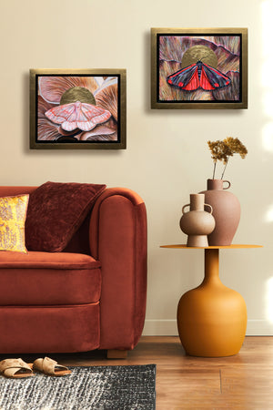 cinnabar moth mushroom painting in gold float frame hanging over side table