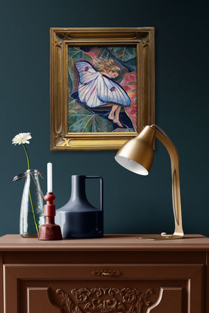 sleeping fairy painting in gold leaf frame on dark teal wall