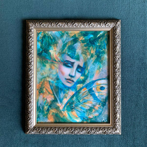 'Our Skin is Melted Moons' emotional art teal, yellow, green colorful acrylic painting of female face with butterfly wings in antique silver frame on teal wall by aimee schreiber