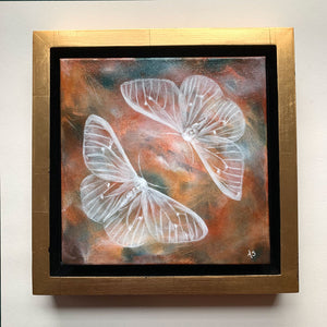 Ethereal moths colorful original painting by Aimee Schreiber in a gold floater frame on white wall