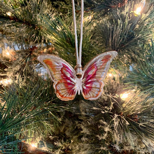 pink, orange, gold butterfly ornament on tree