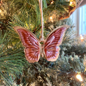 Rust, pink, gold butterfly ornament on tree