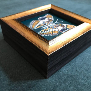 tiny teal, white and gold leaf butterfly painting in a gold frame side detail
