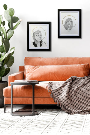 2 portrait drawings hanging over a sofa