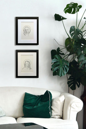 2 haloed women portrait drawings on wall over sofa
