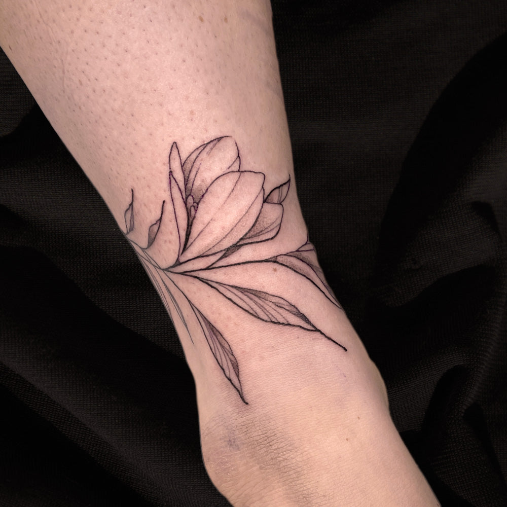 fine line ankle flower tattoo by Cass Brown