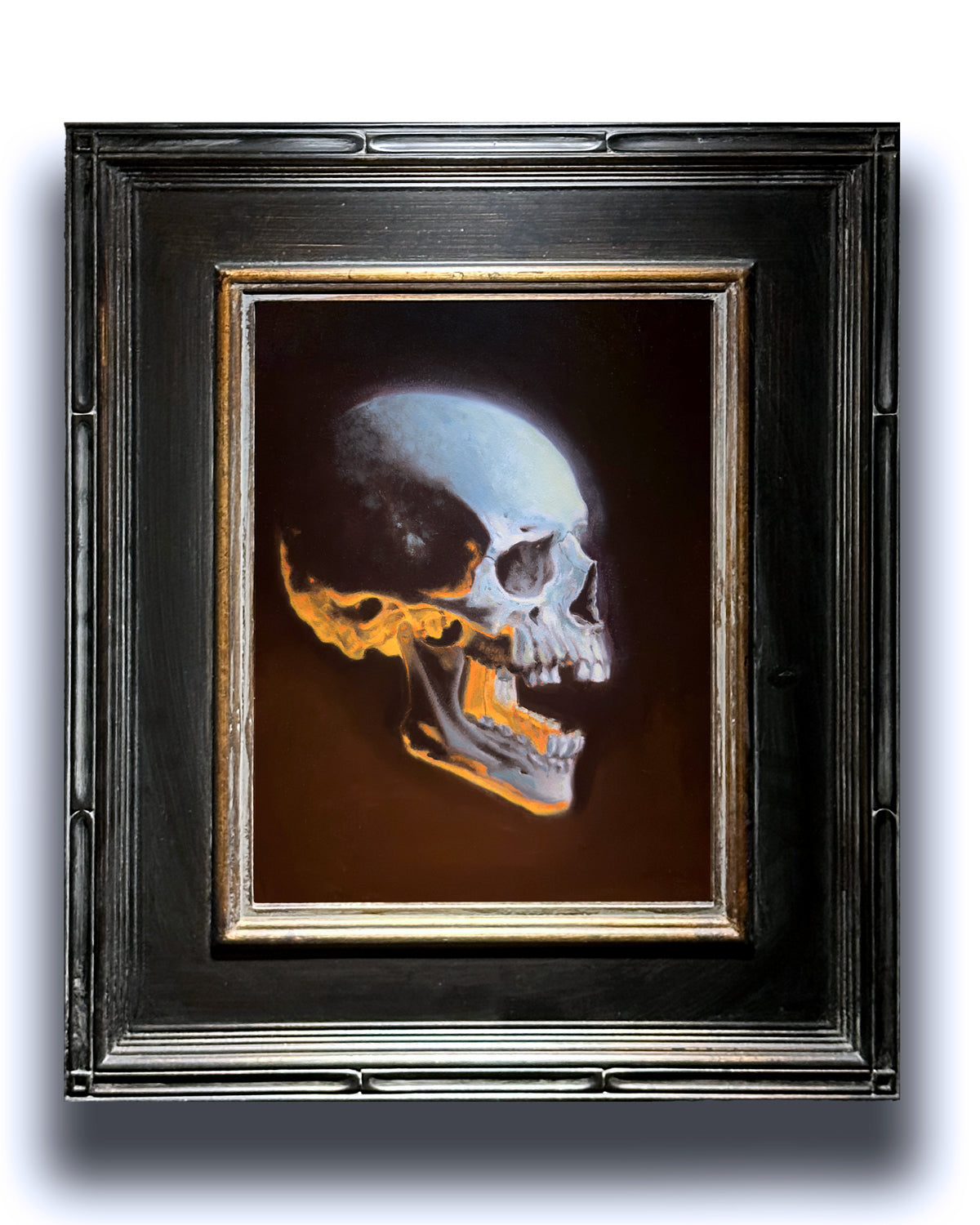 glowing skull oil painting in black frame