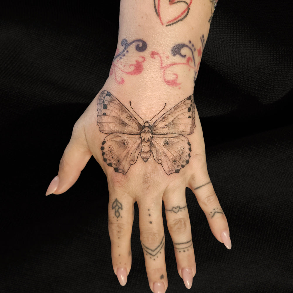 butterfly hand tattoo by Lydia Pitts