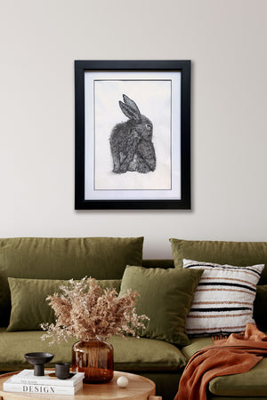 rabbit charcoal drawing hanging over green sofa