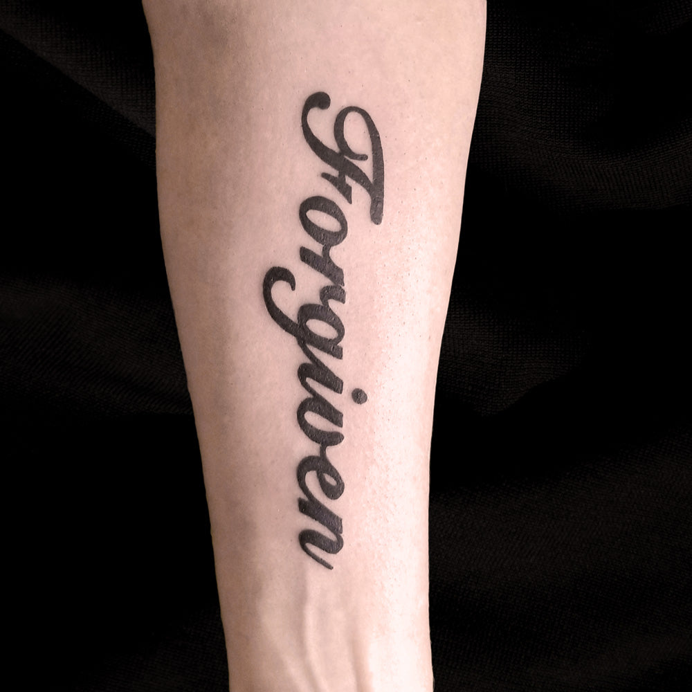 Forgiven text tattoo by Lydia Pitts