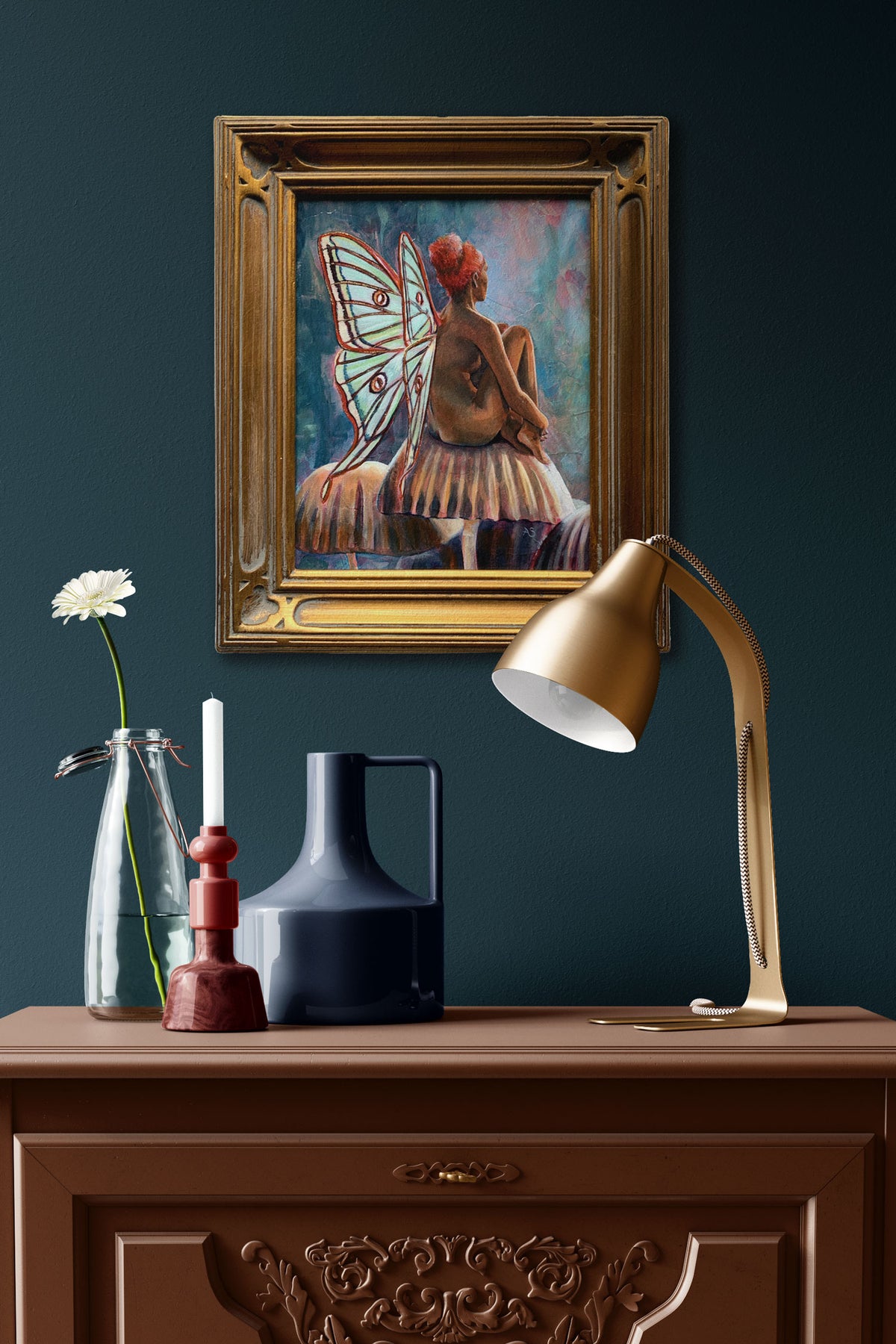 fairy painting with green wings and gold frame hanging on wall over side table
