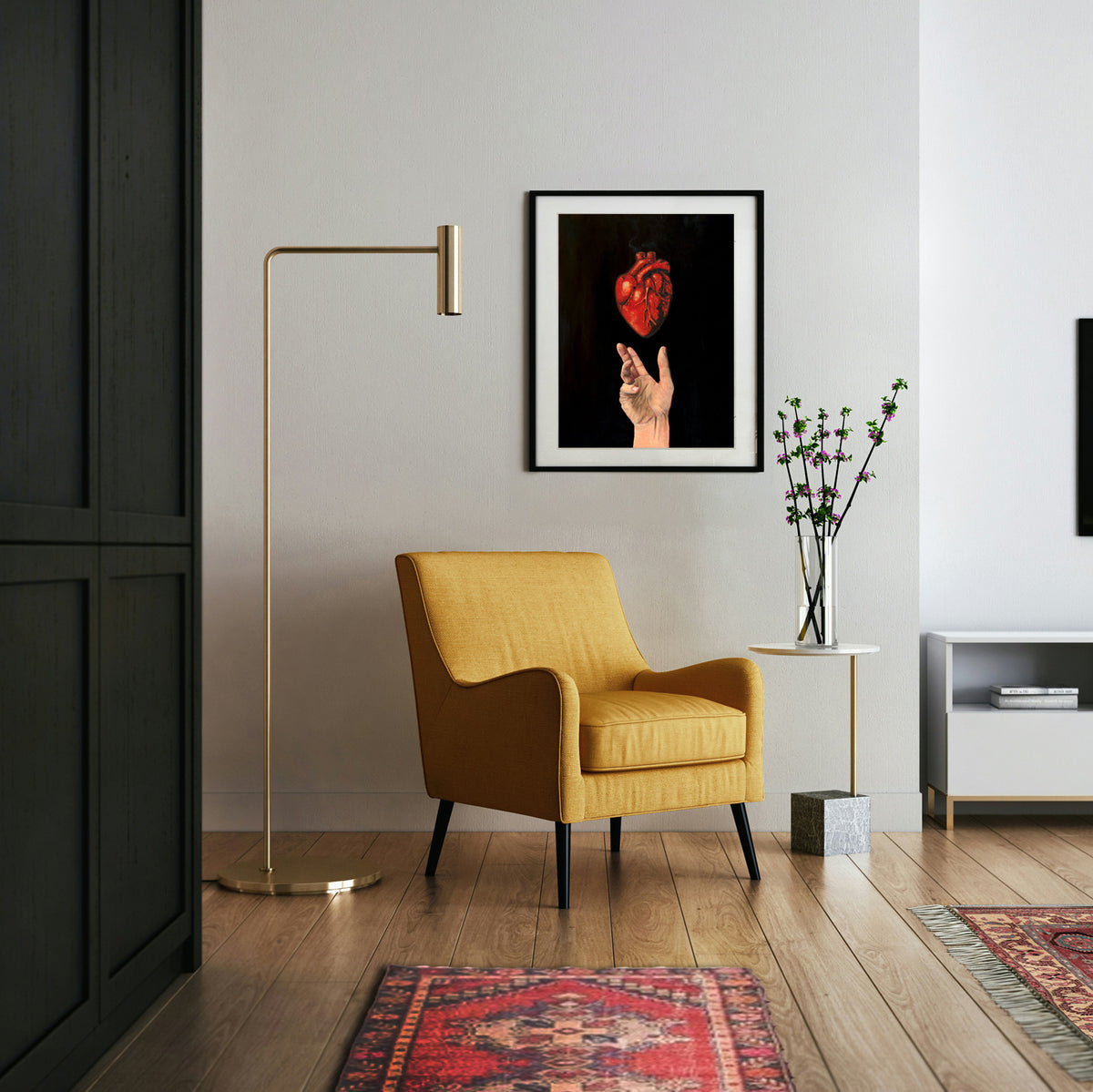 art print of an open hand with an anatomical heart hovering above it on a black background hanging on a wall