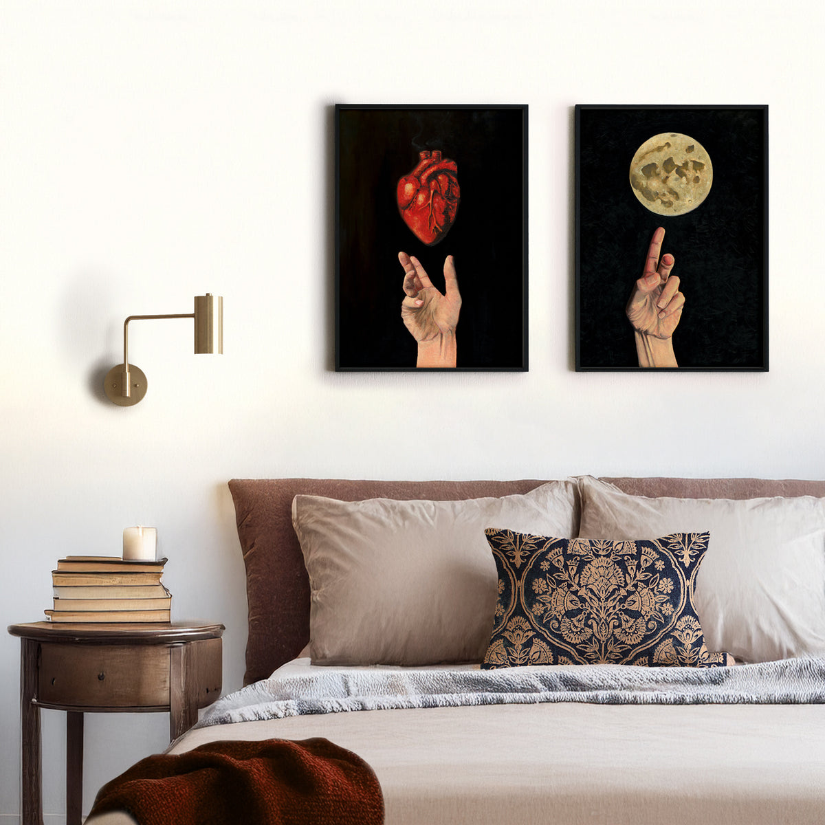 2 art prints of hands hanging above a bed