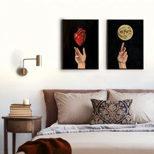2 art prints of hands hanging above a bed