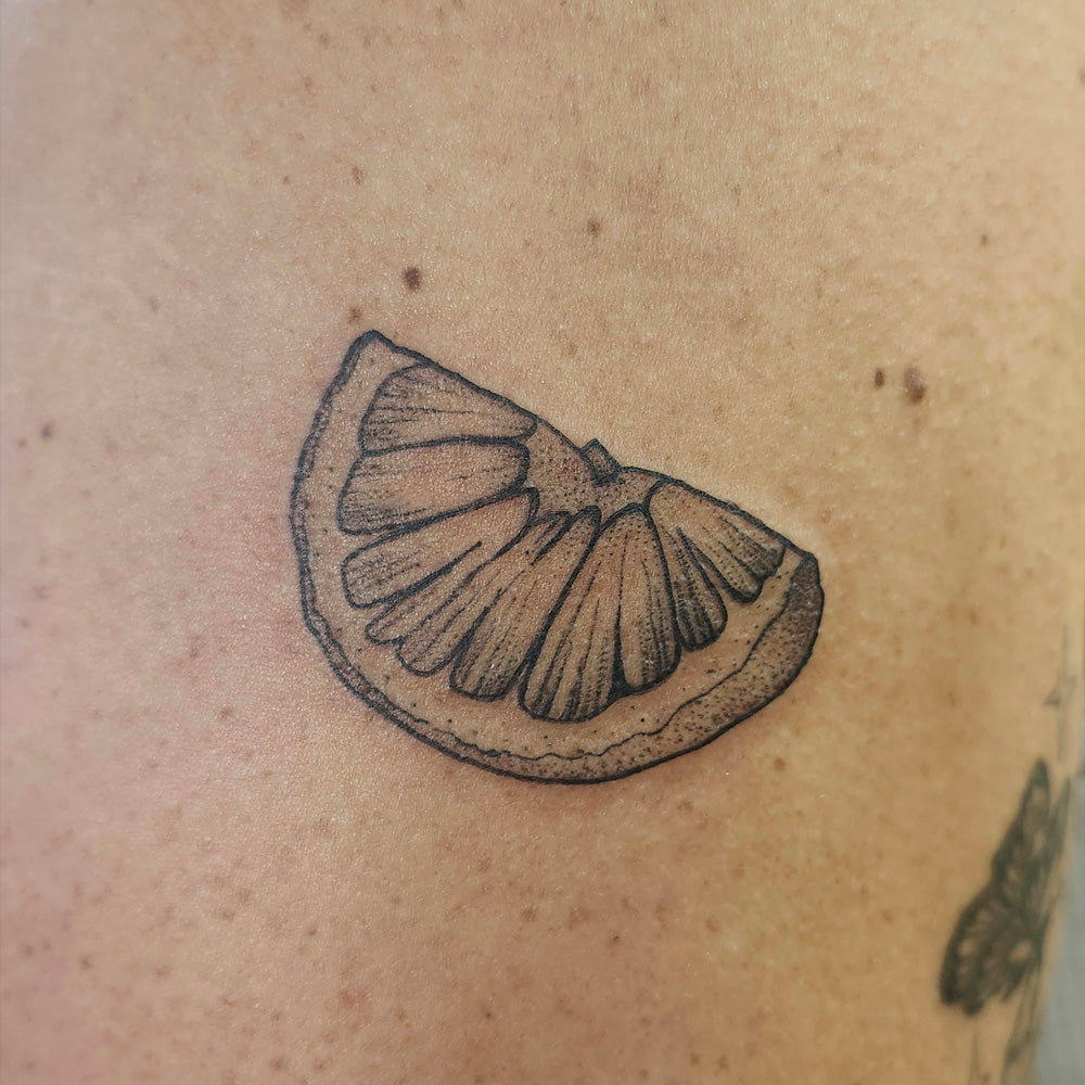 lemon slice fine line tattoo by Lydia Pitts
