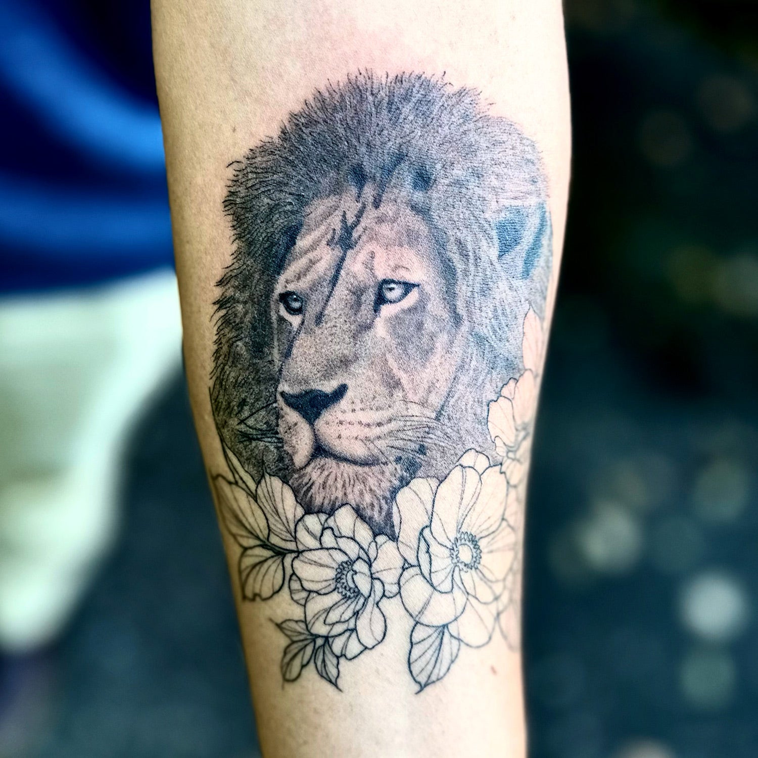 lion tattoo with flowers by Danny Schreiber