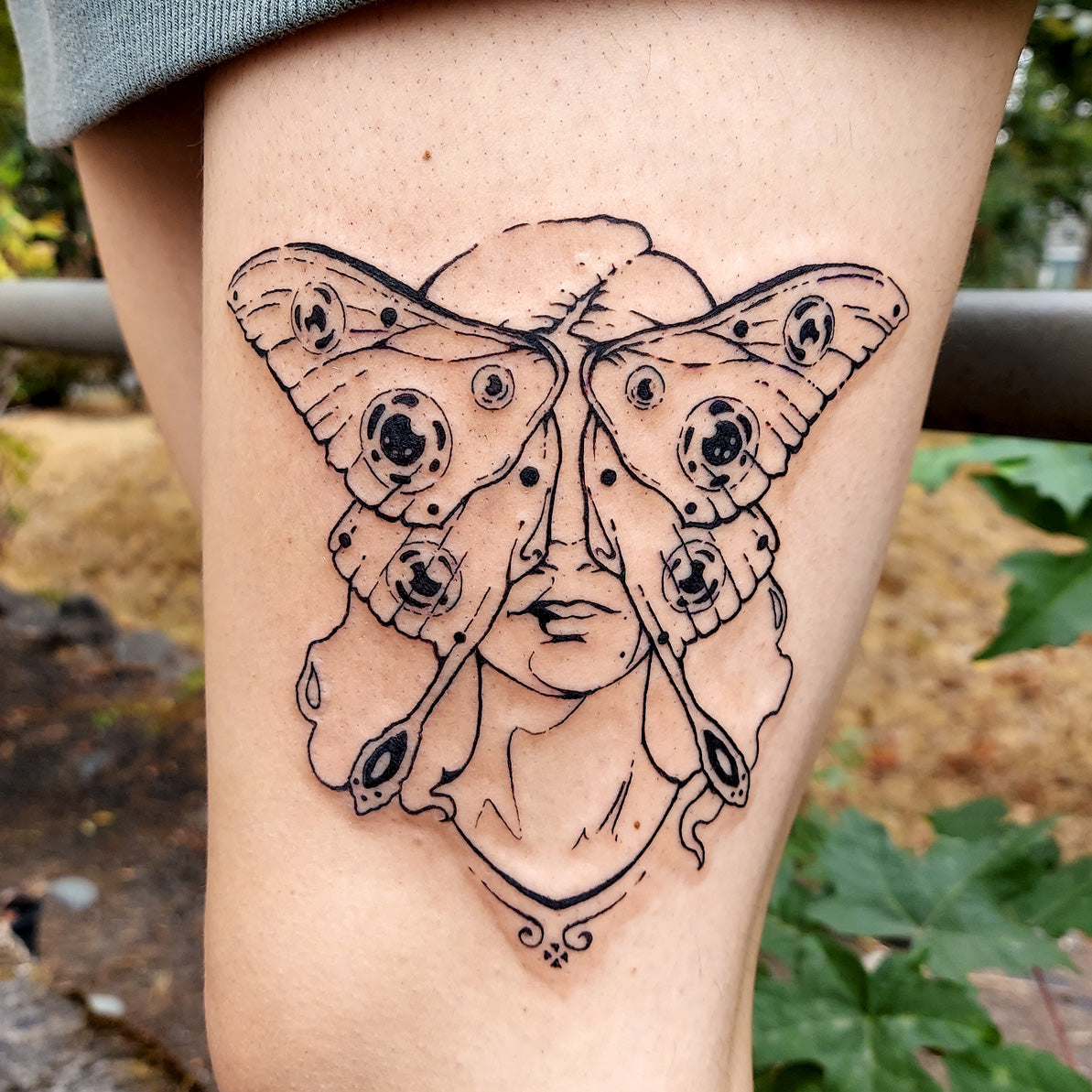 luna moth face tattoo on thigh by Vincent Li