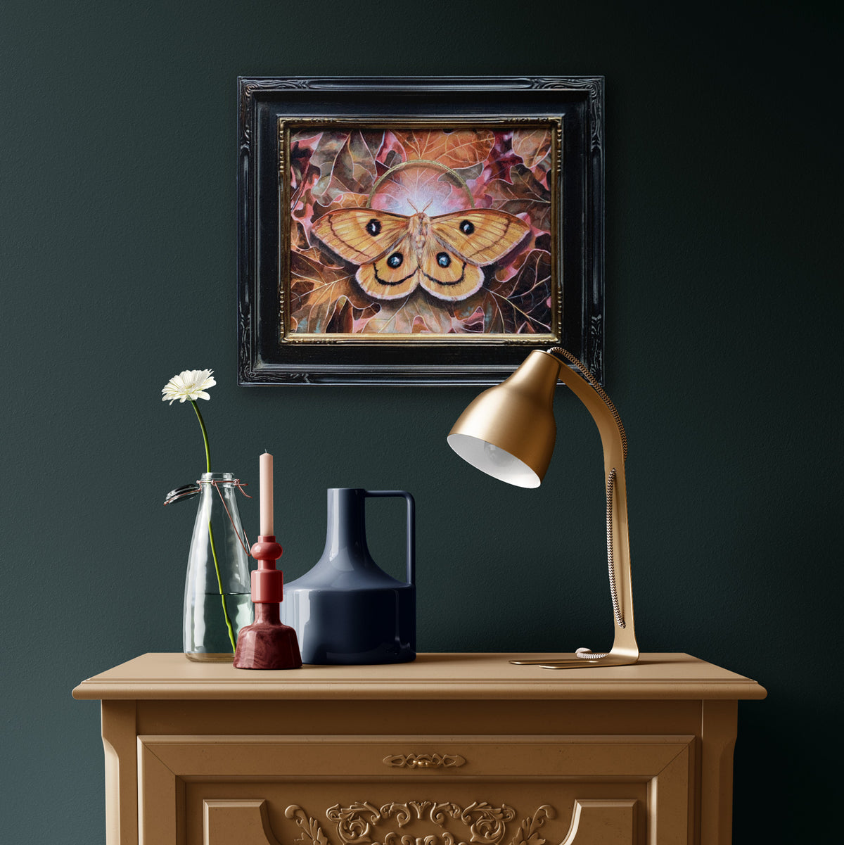 &#39;Alchemy&#39; yellow tau emperor moth painting hanging on dark wall