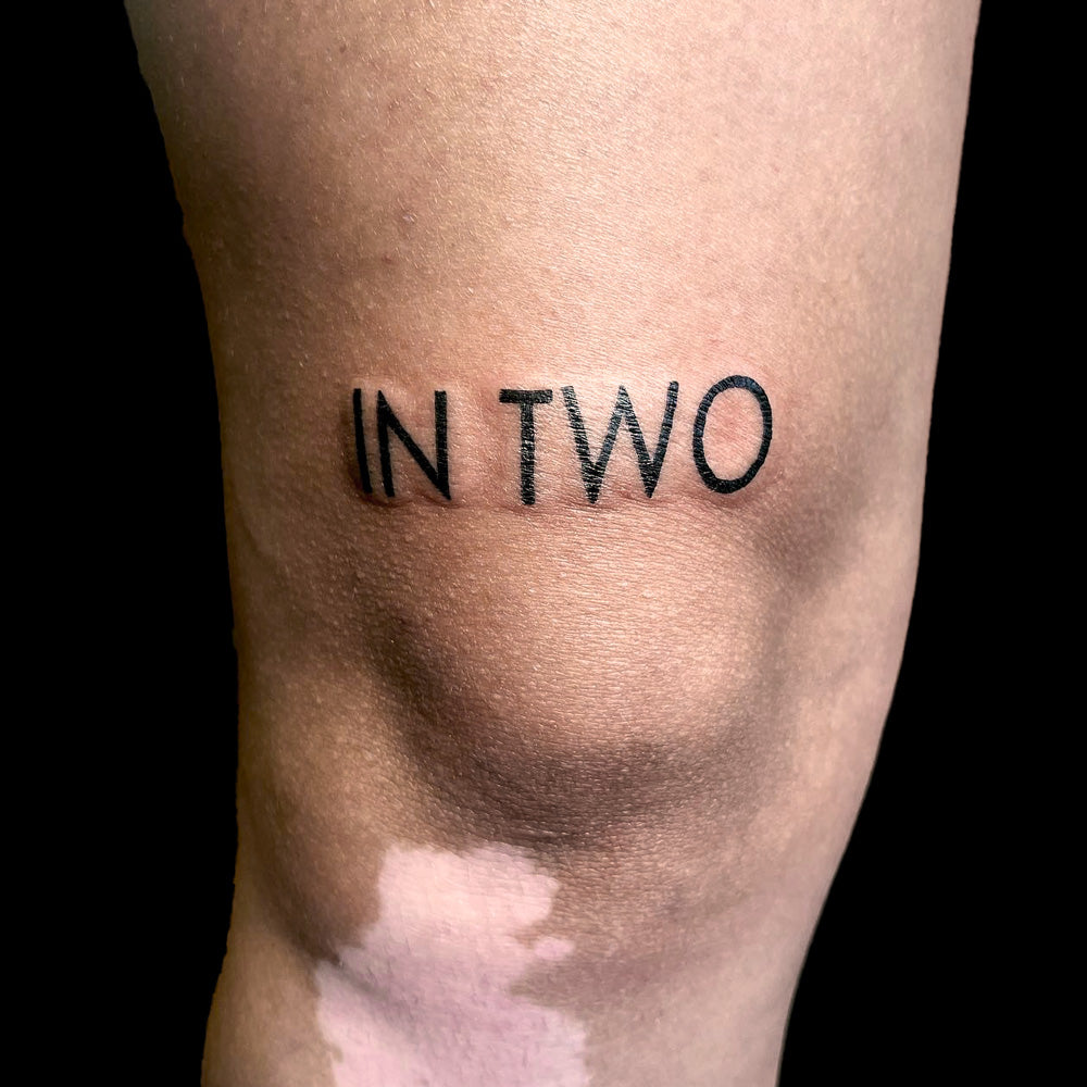 text tattoo over knee by Juniper Jack