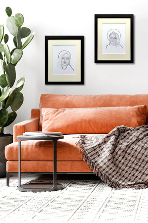 portrait drawings pair over orange sofa