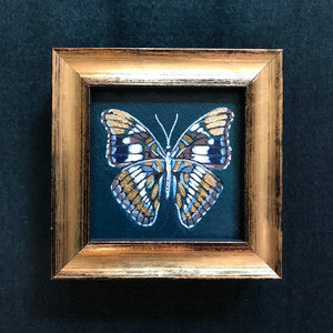 tiny teal, white and gold leaf butterfly painting in a gold frame