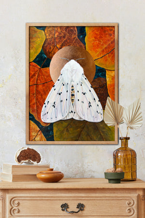 white ermine moth art print framed on wall over dresser